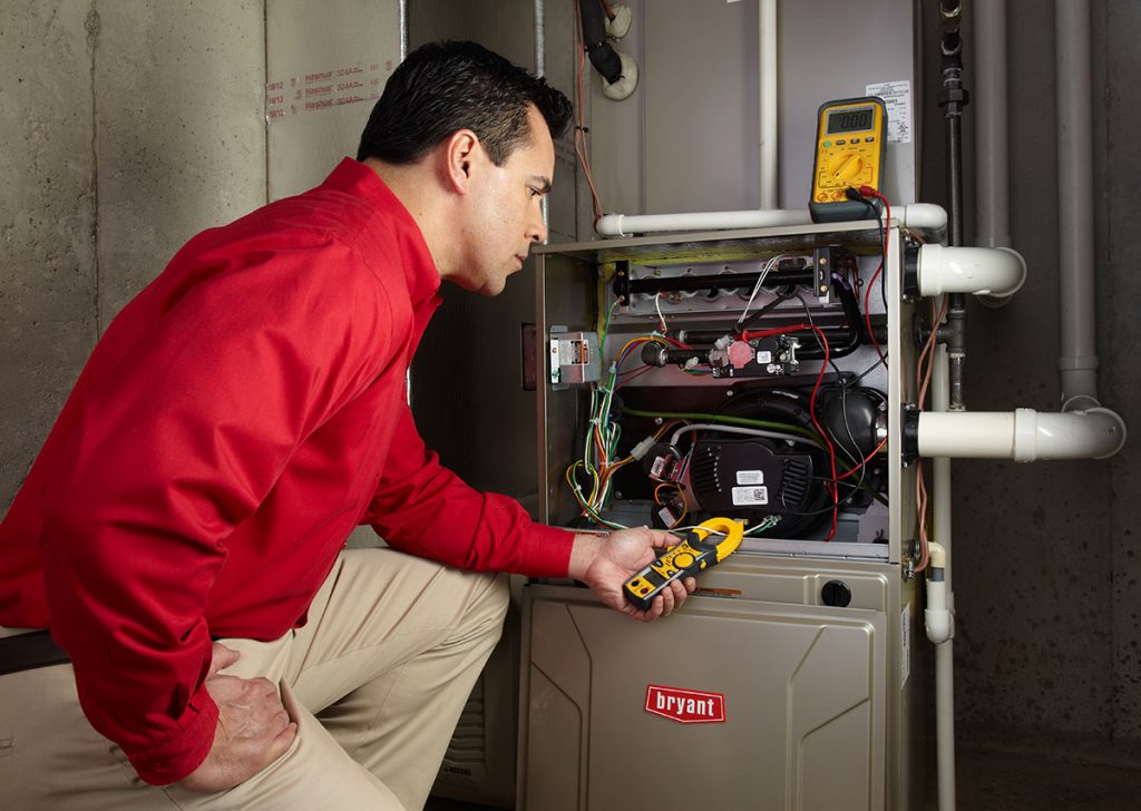 HVAC technician repairing an indoor furnace in Springville