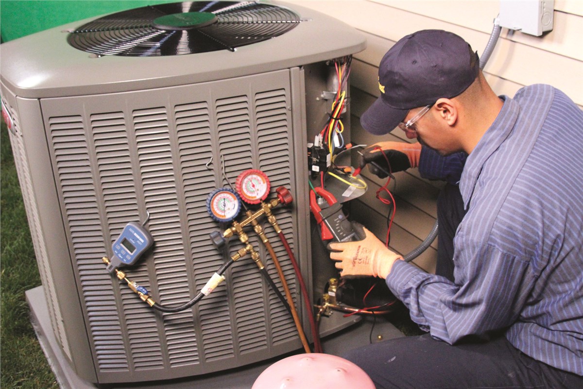 HVAC technician testing an outdoor air conditioning unit in Springville