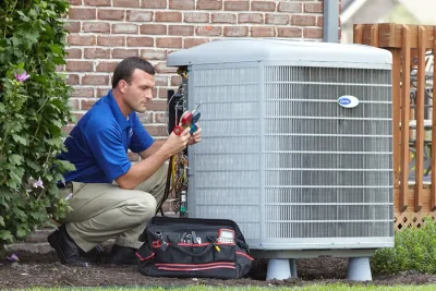 design-air-heating-and-air-conditioning-decatur-il-05 – Copy HVAC technician inspecting an outdoor air conditioning unit in Springville, UT